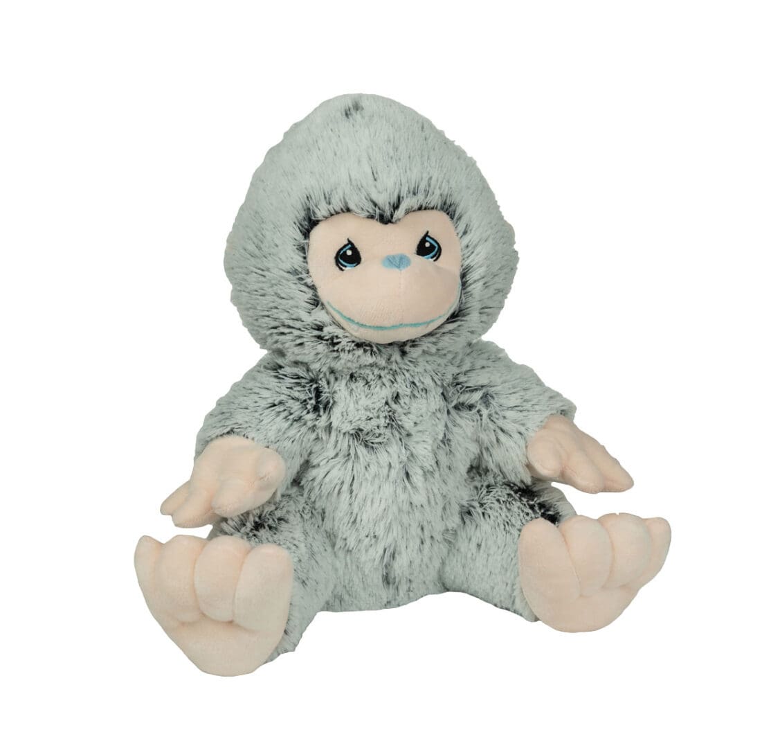 A stuffed monkey is sitting down and looking at the camera.