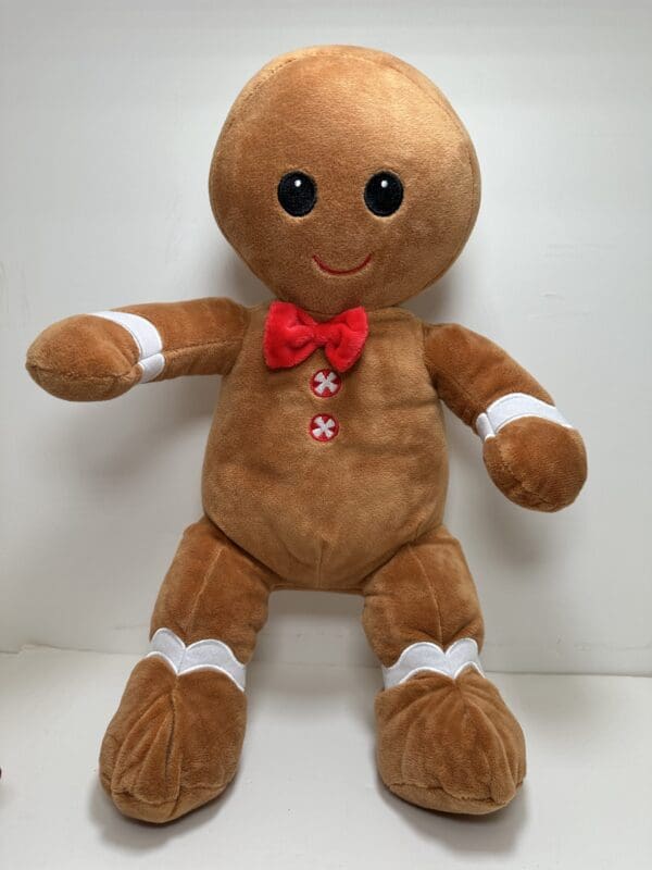 A stuffed gingerbread man with red bow tie.