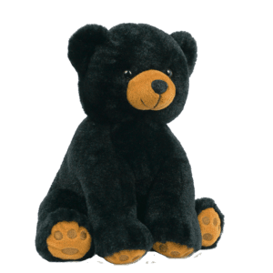 A black teddy bear with orange ears sitting on top of a green background.