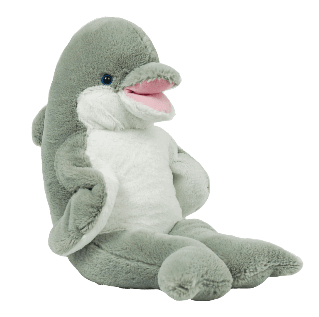 A stuffed dolphin sitting on top of a green background.