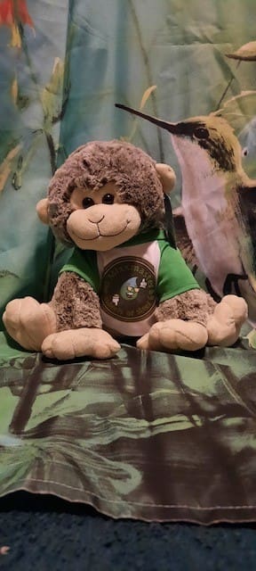 A stuffed monkey sitting on top of a bed.